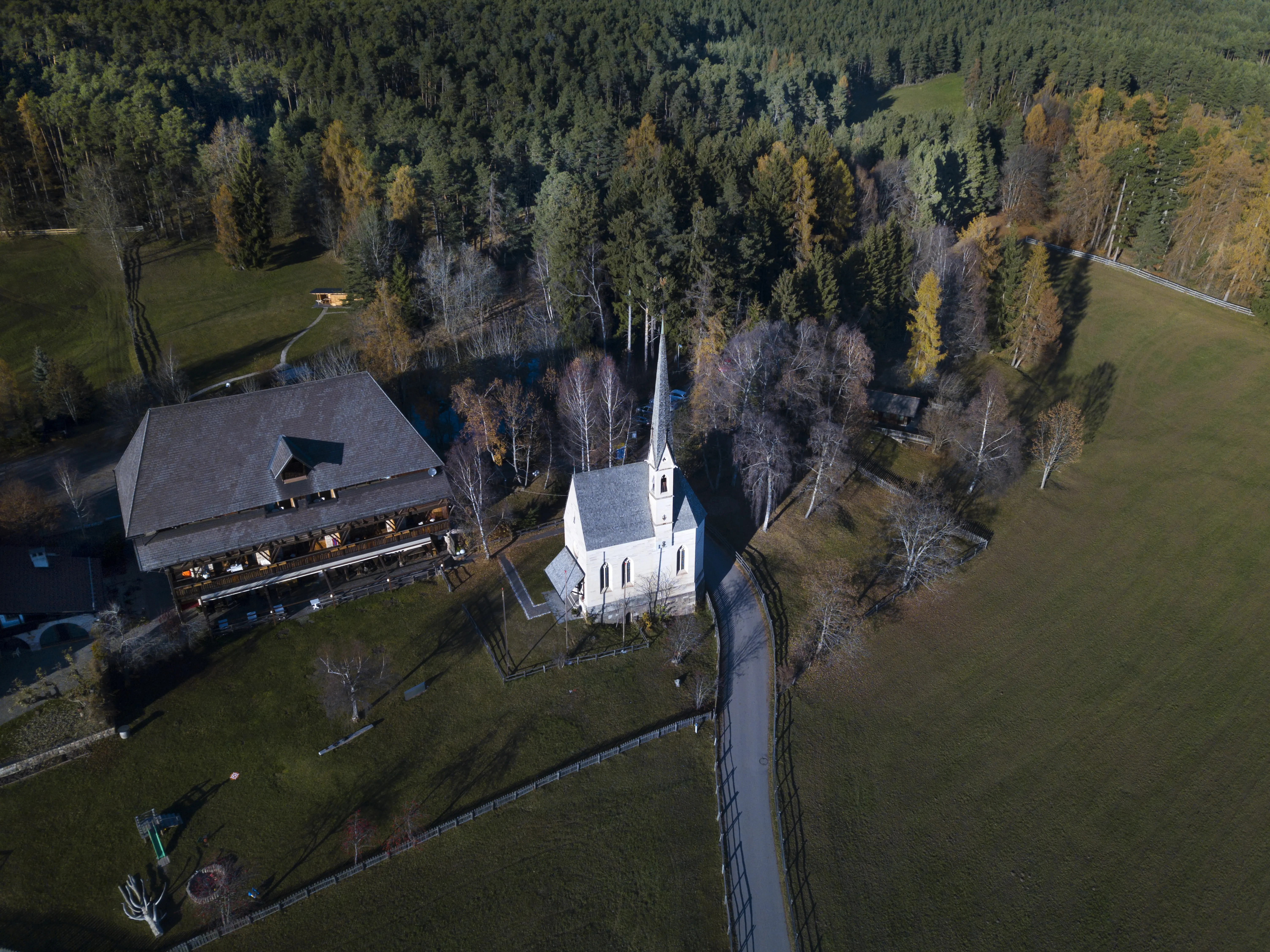 Blick aus großer Höhe auf Häuser bei Bäumen und Gebäuden.