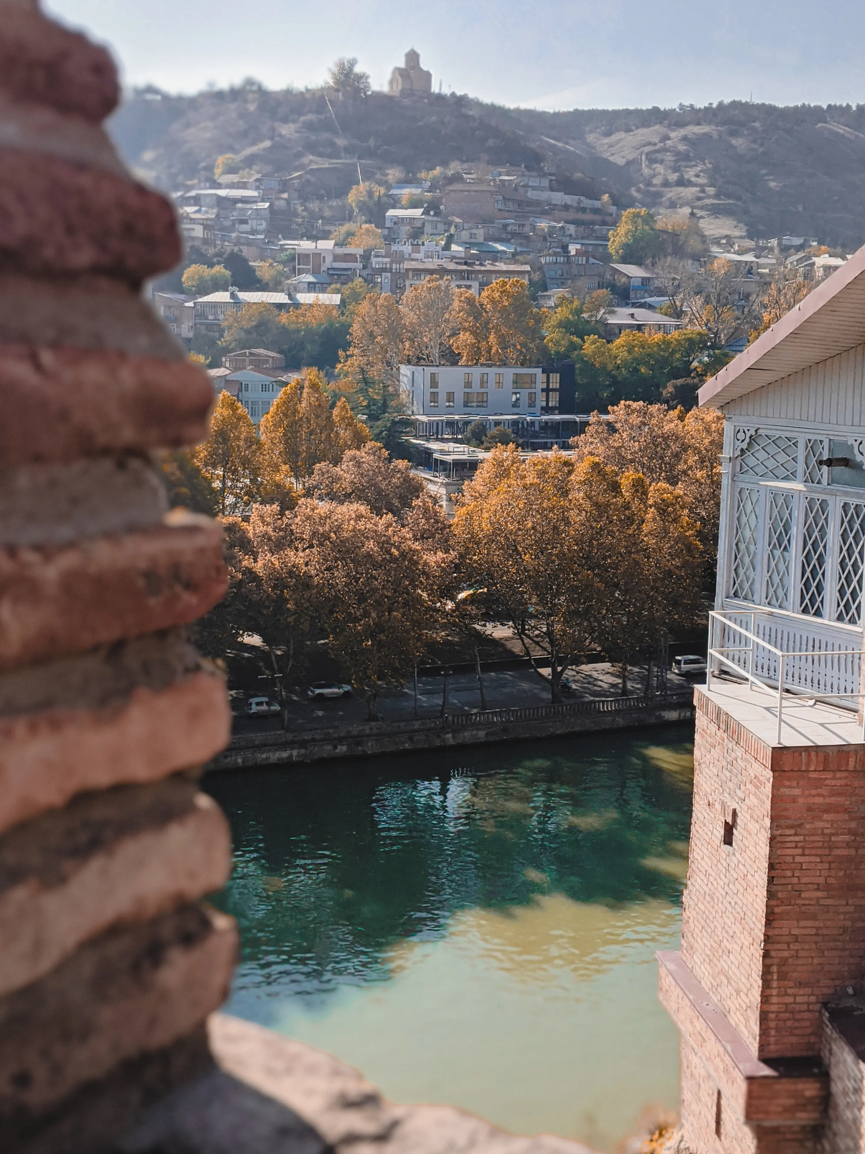 Malerischer Blick auf einen Fluss entlang von Gebäuden mit einem Berg im Hintergrund.